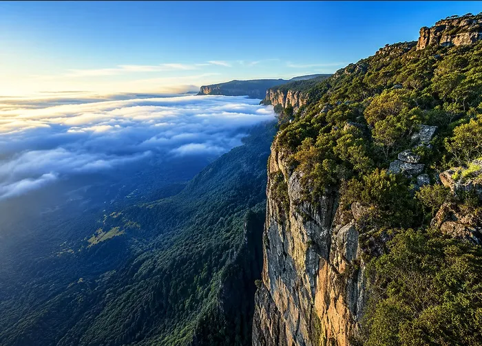A mountain ridge above a sea of clouds at sunrise